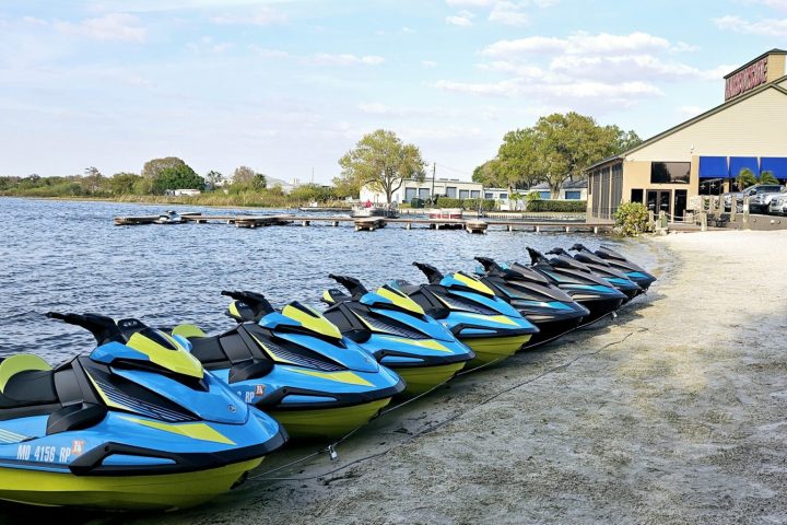 a row of cars on a sandy beach next to a body of water