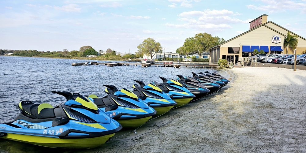 a row of cars on a sandy beach next to a body of water