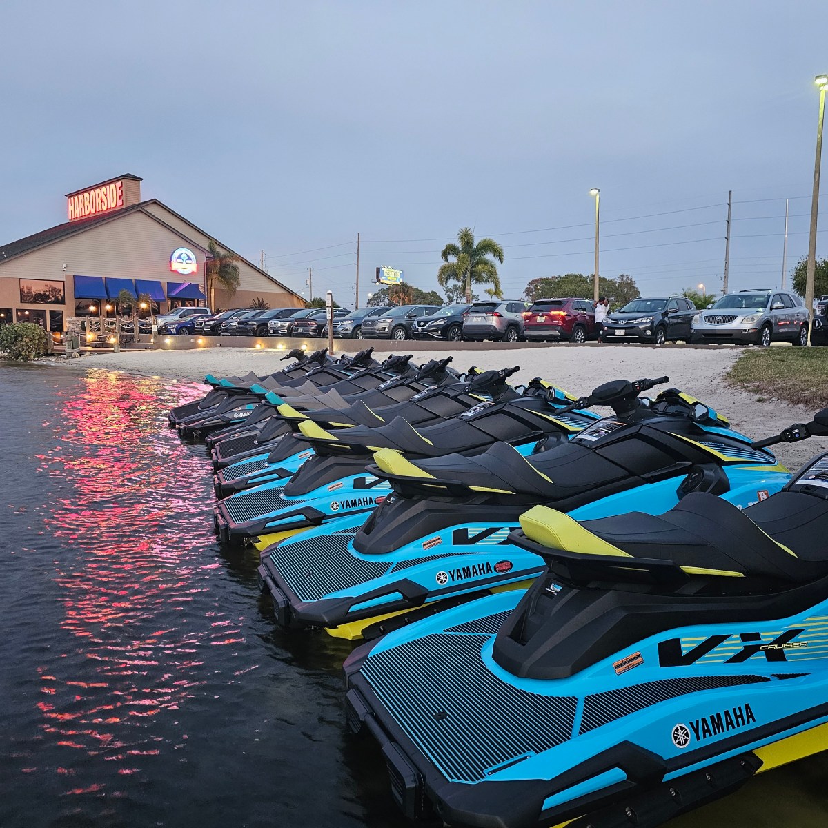 a row of parked motorcycles sitting next to a body of water